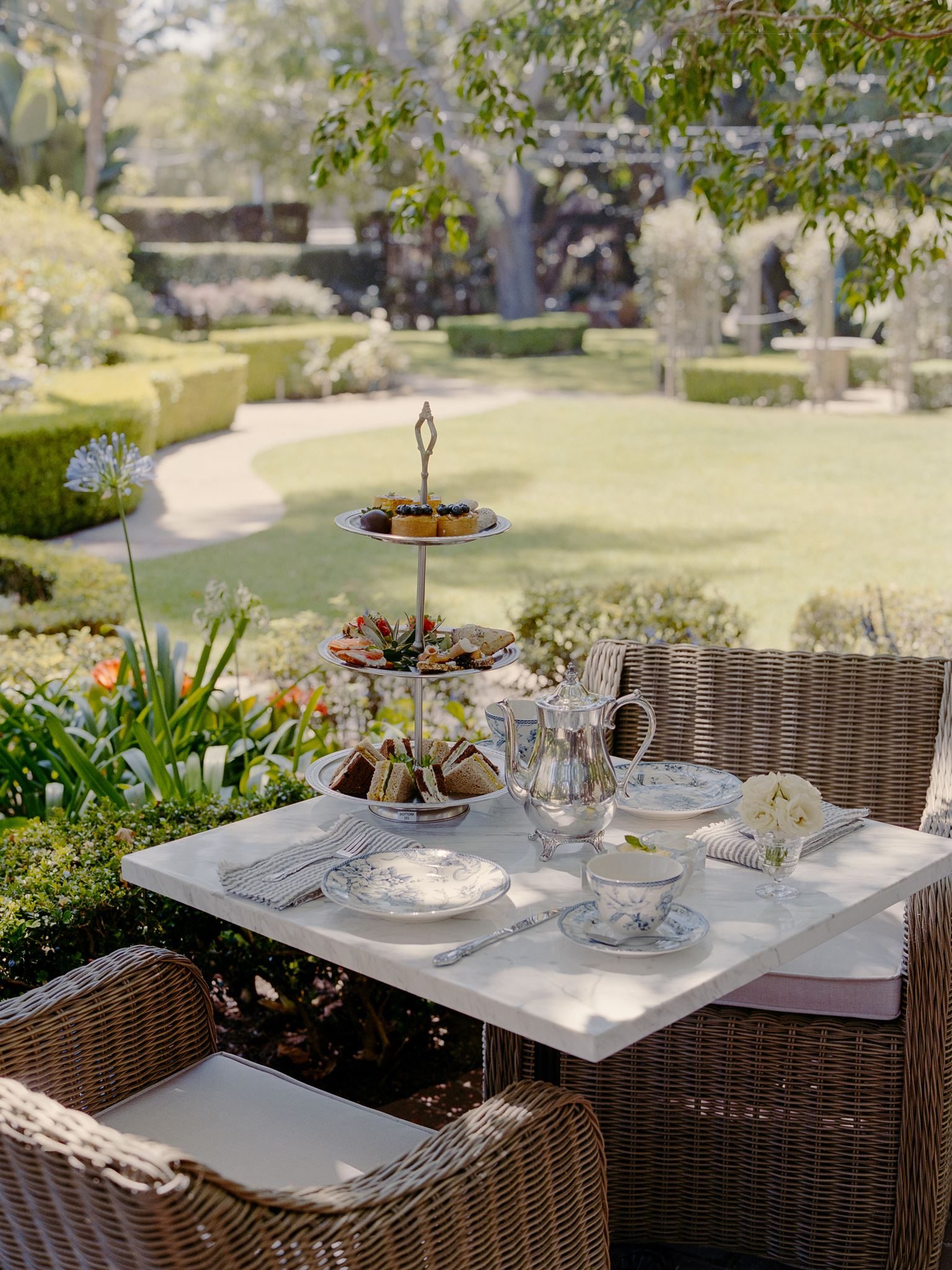 A three-tiered afternoon tea service on a garden table at the Simpson House Inn