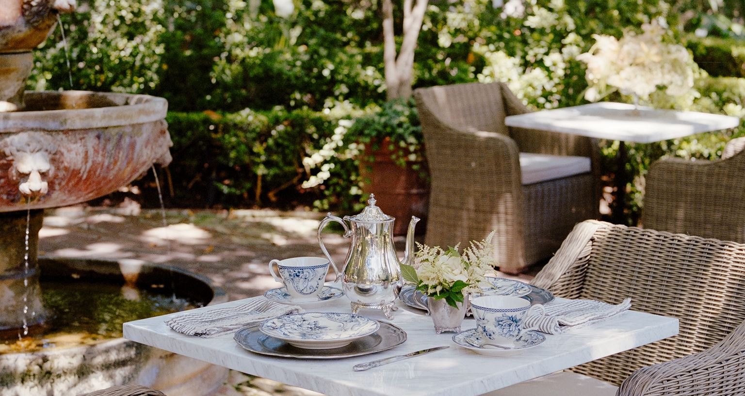 A tea table set beneath the trees in the Simpson House gardens