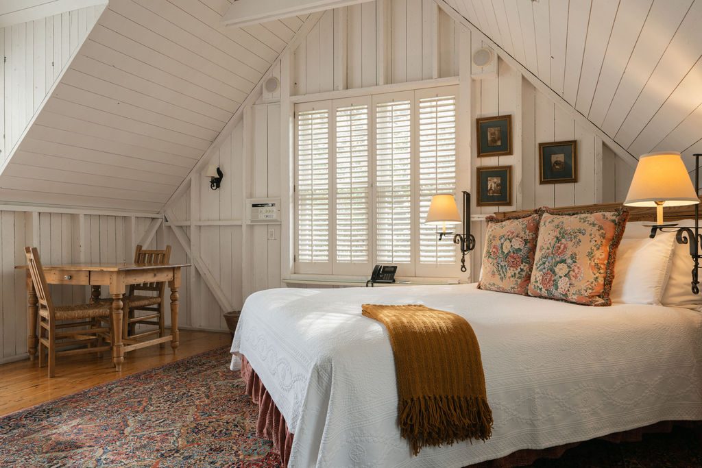 The king bed beneath the beams of the Hayloft