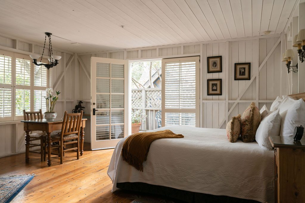 The king bed and curated antiques in the Tack Room
