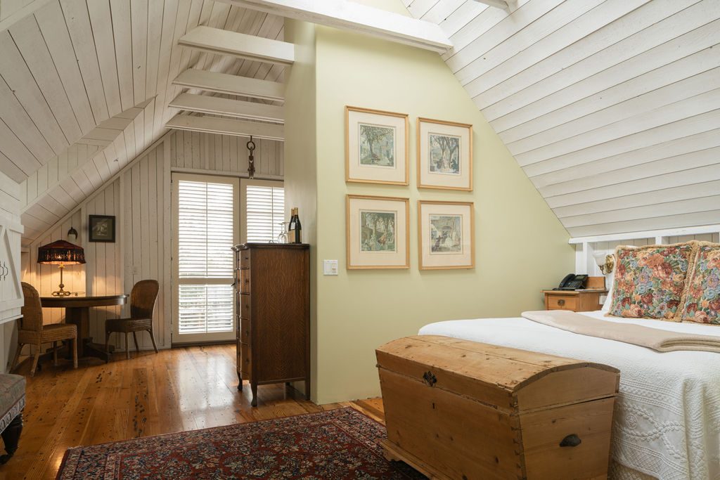 The king bed beneath vaulted ceilings in the Weathervane Room